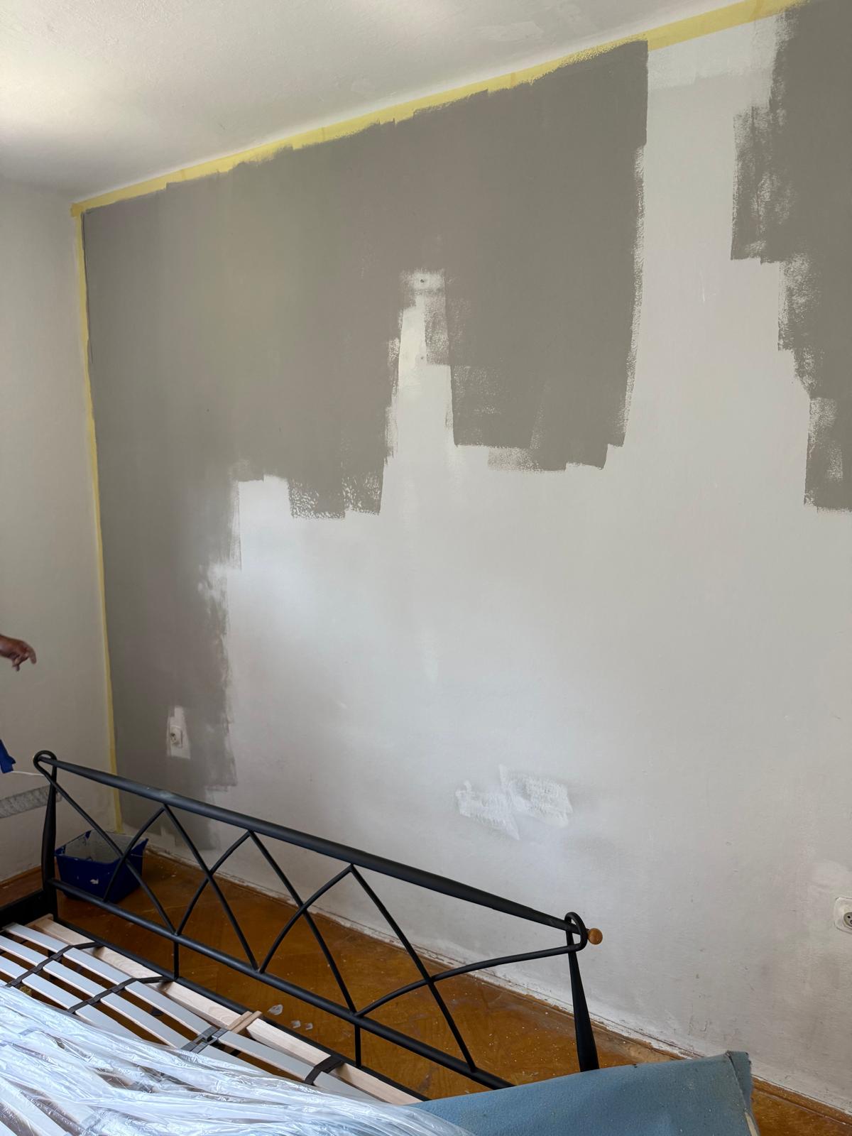 Malování šedé stěny v průběhu realizace